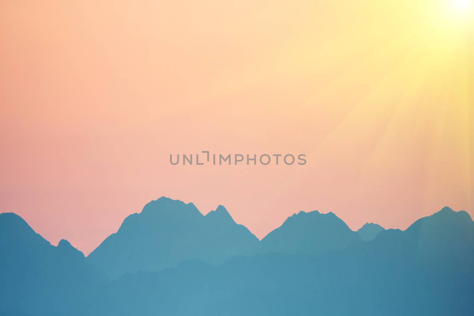 Beautiful orange sunset over mountains. Bright sun with sunrays. Cagliari, Sardinia, Italy.