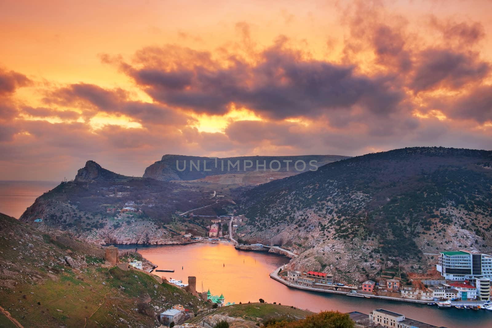 Ancient greek castle on the coast. Sunset above Balaklava bay.