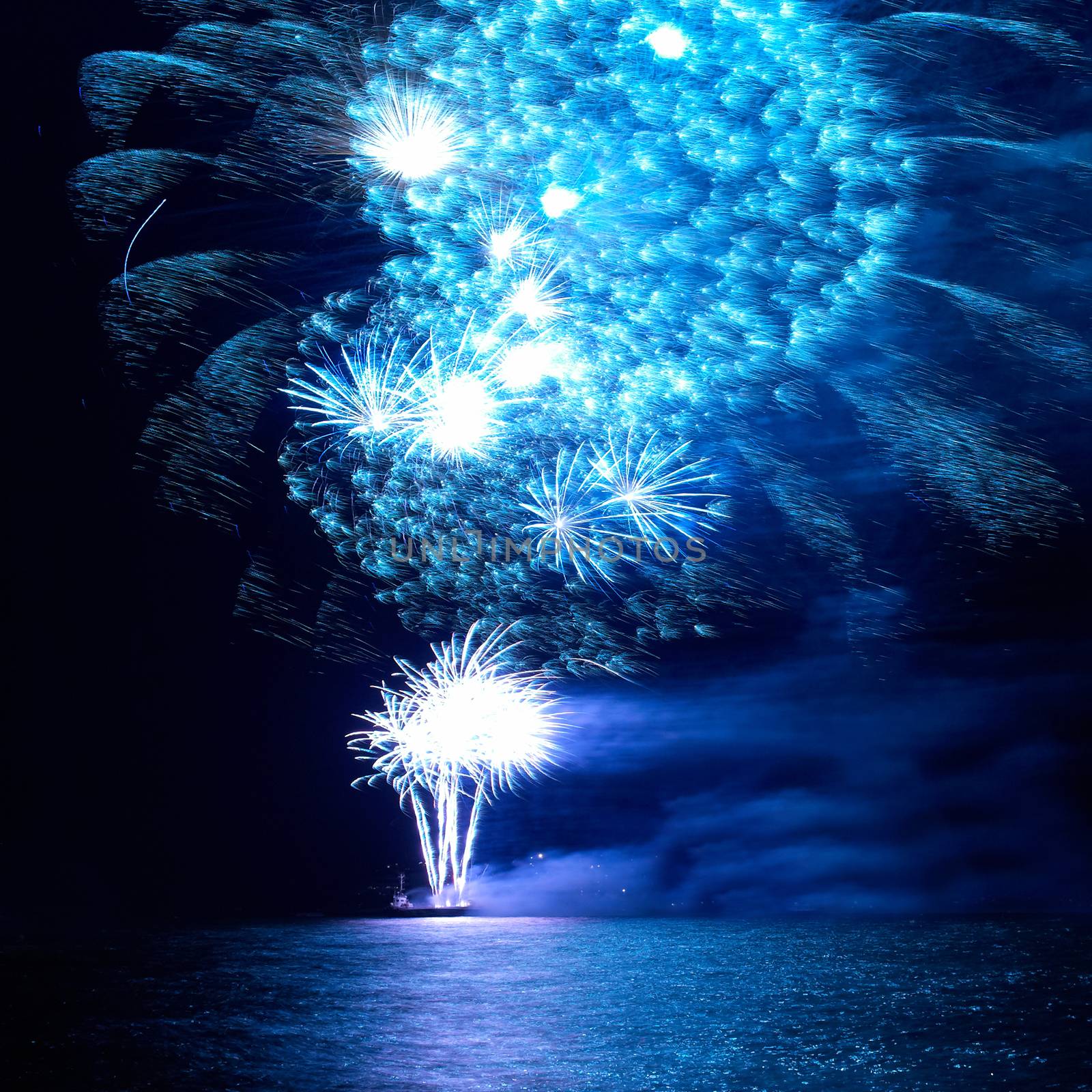 Blue colorful holiday fireworks on the black sky background.