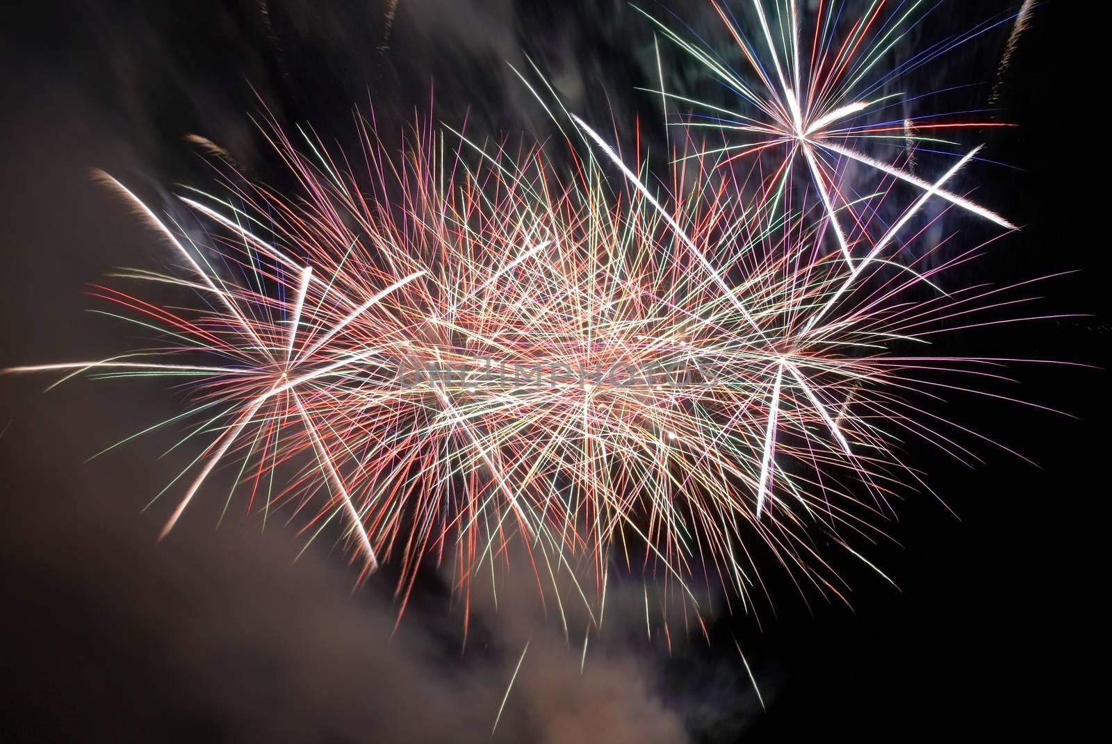 Red colorful fireworks on the black sky background. Holiday celebration.