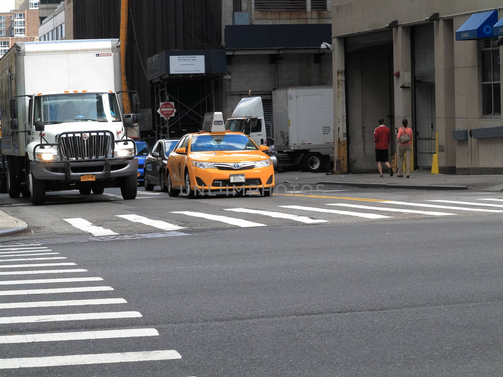 A NYC taxi cab at a crosswalk.