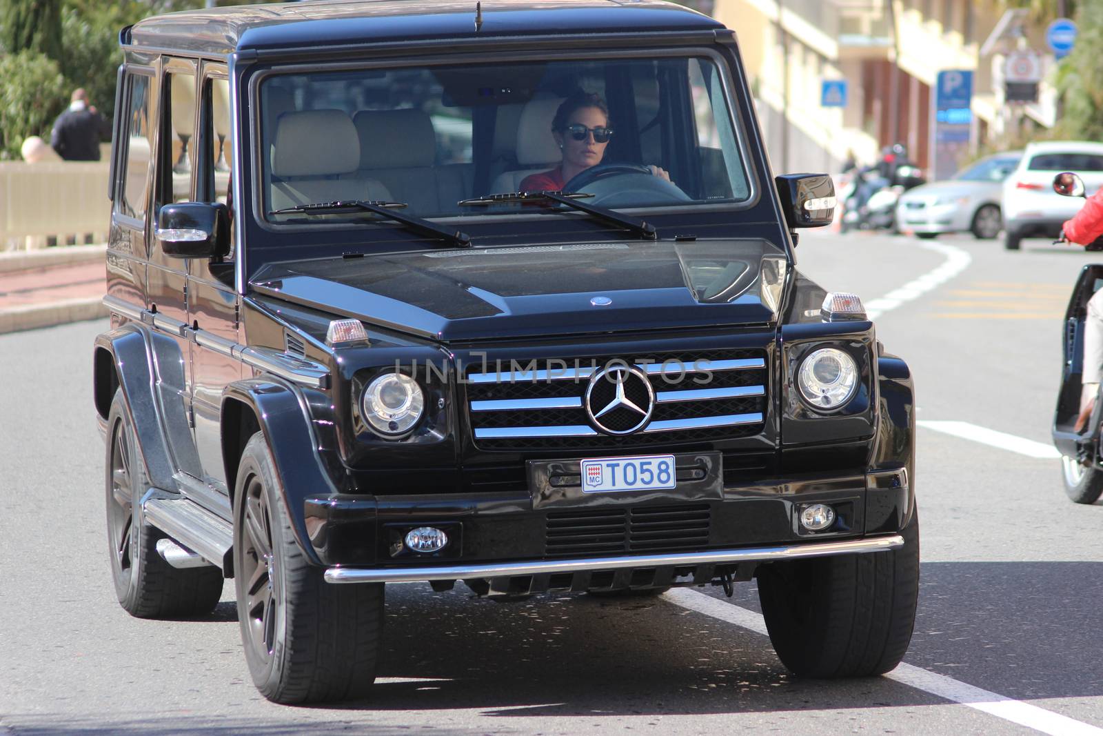 Monte-Carlo, Monaco - March 9, 2016: Mercedes AMG G 65 on Avenue d'Ostende in Monaco. Beautiful Young Woman Driving an Expensive Black SUV in the south of France