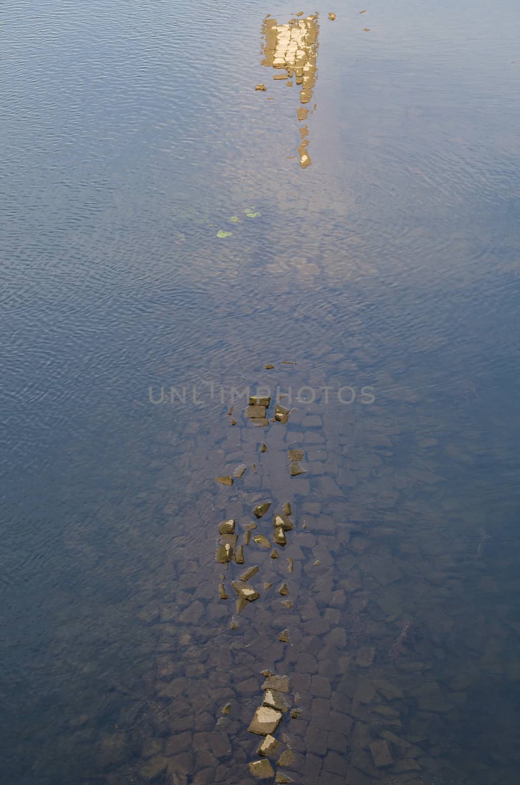 Water surface with sunken remains of walls in the river Ruhr in Hattingen, Germany.