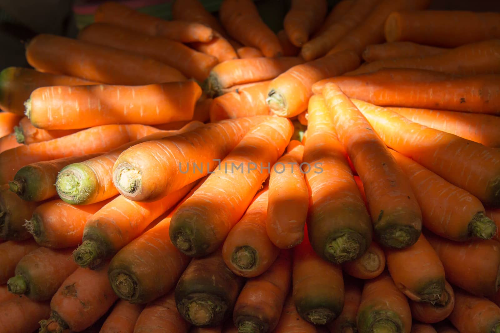 Fresh and tasty carrot nicely organized on the market in Morocco. Enlightened by sun.