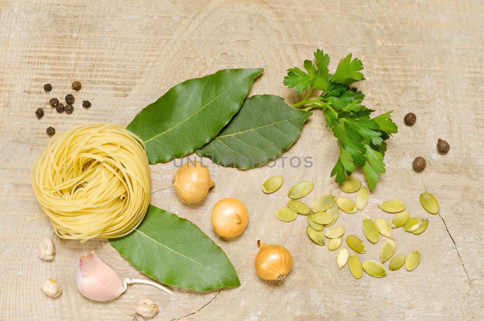 Not the cooked pasta, Bay leaf, onion, garlic and other spices on the old wooden background