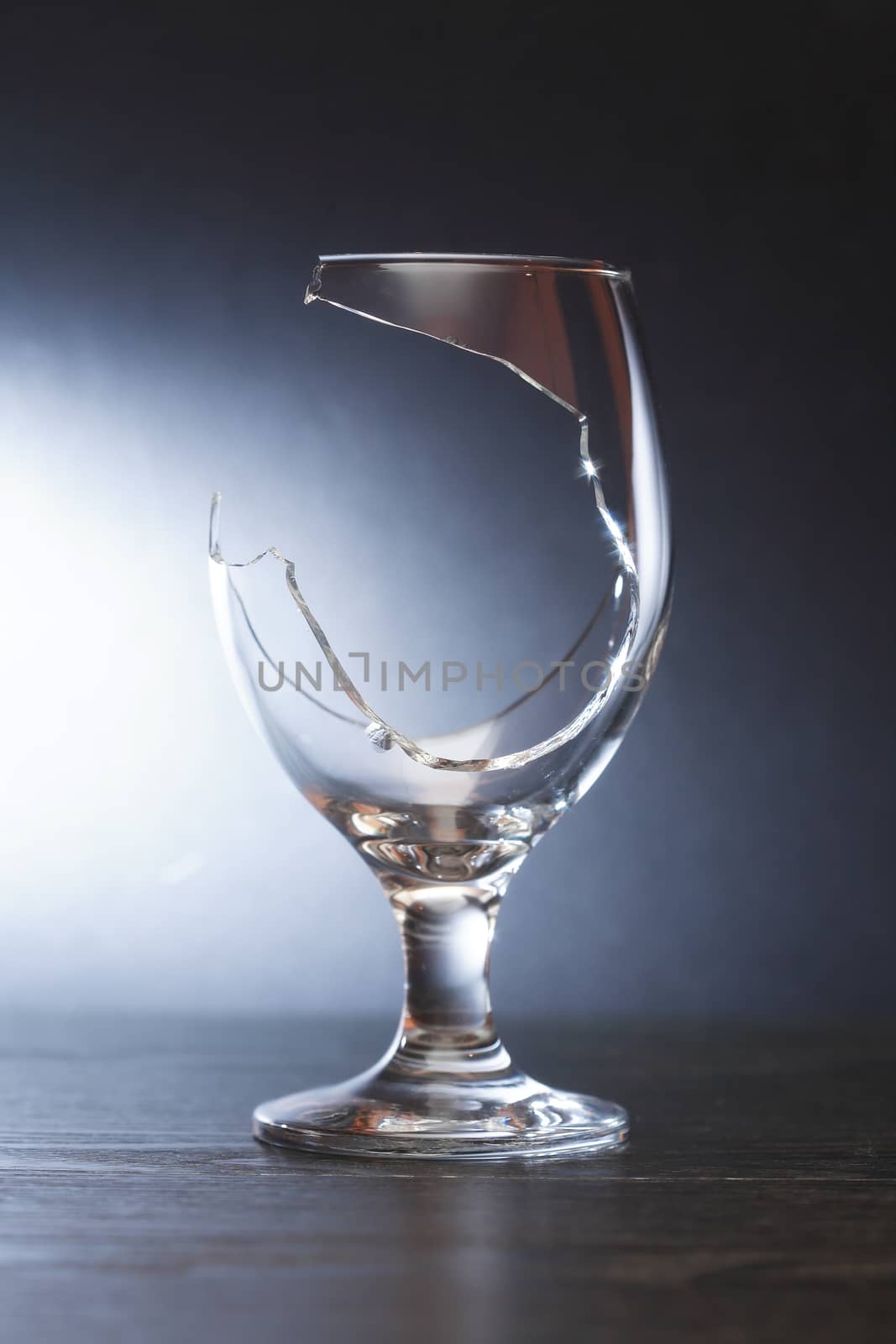 One broken wineglass on nice dark background