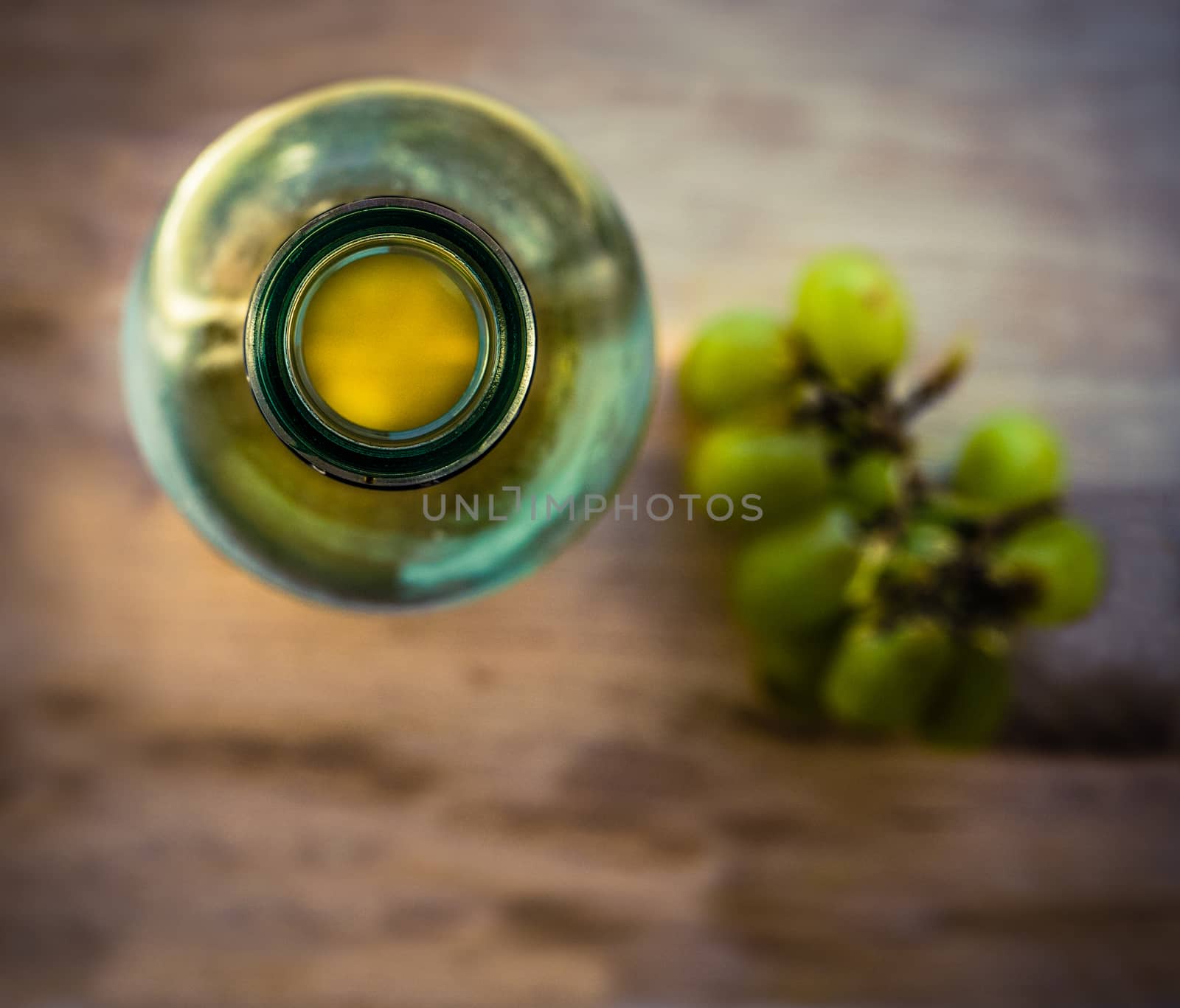 Retro Style Image Of A Rustic Wooden Table With White Wine Bottle And Grapes