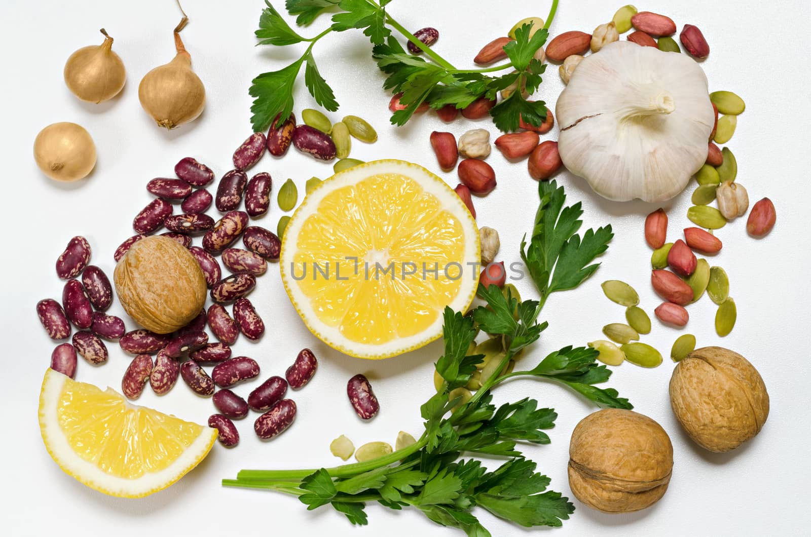 Lemon slices, beans,nuts and spices lie groups on a white background. Parsley, onion, garlic