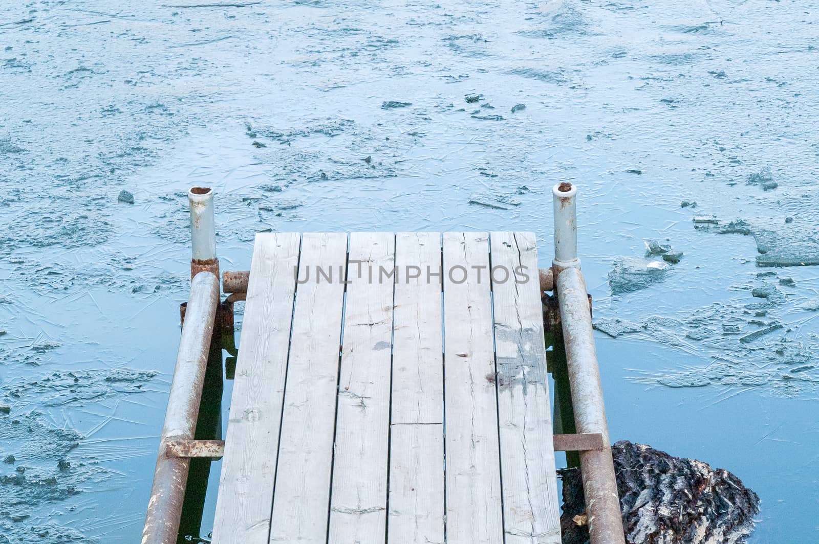 wooden pier, bridge of ice in the water