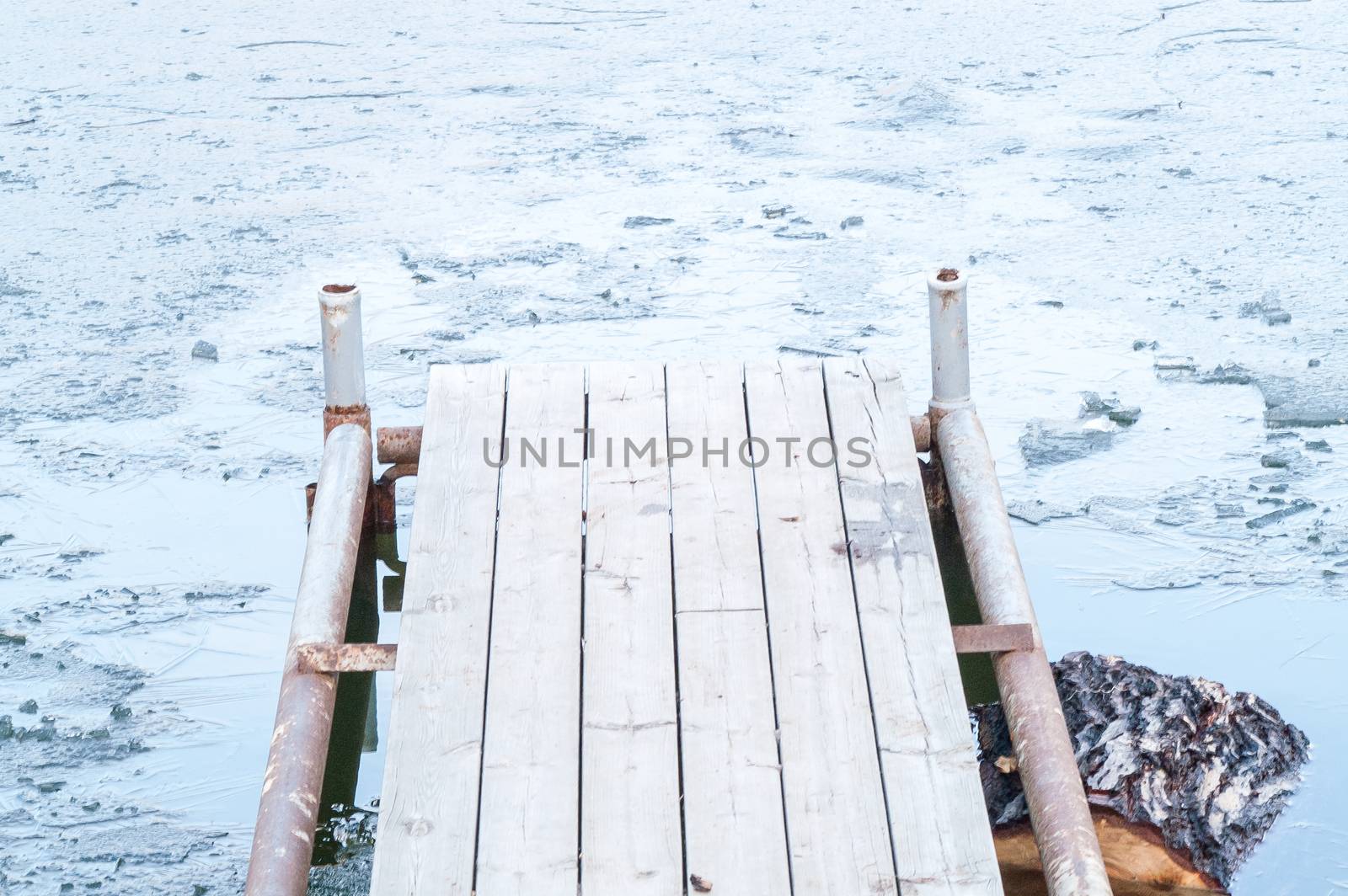 wooden pier, bridge of ice in the water