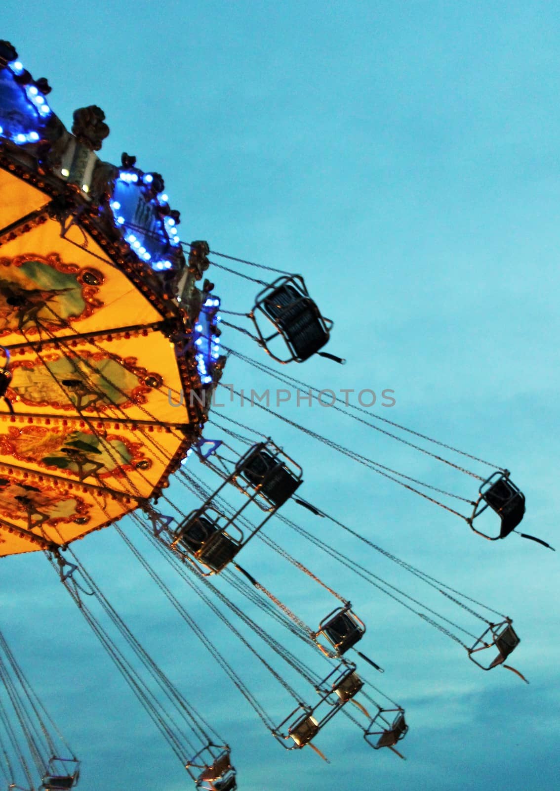 swings carousel Night colors of the amusement park lights moving, light trails, slow shutter-speed by cheekylorns