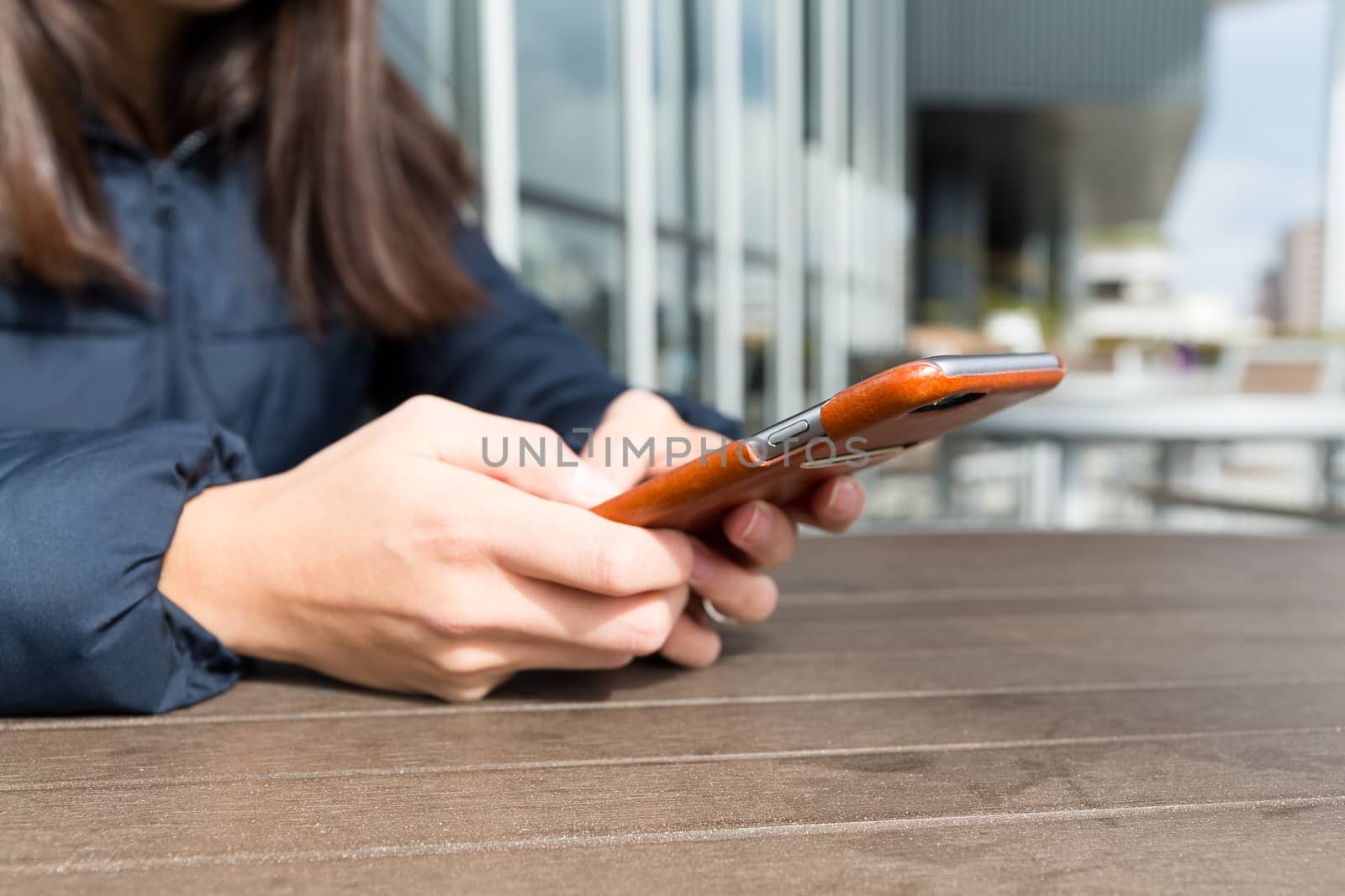 Woman play game on cellphone at outdoor cafe by leungchopan