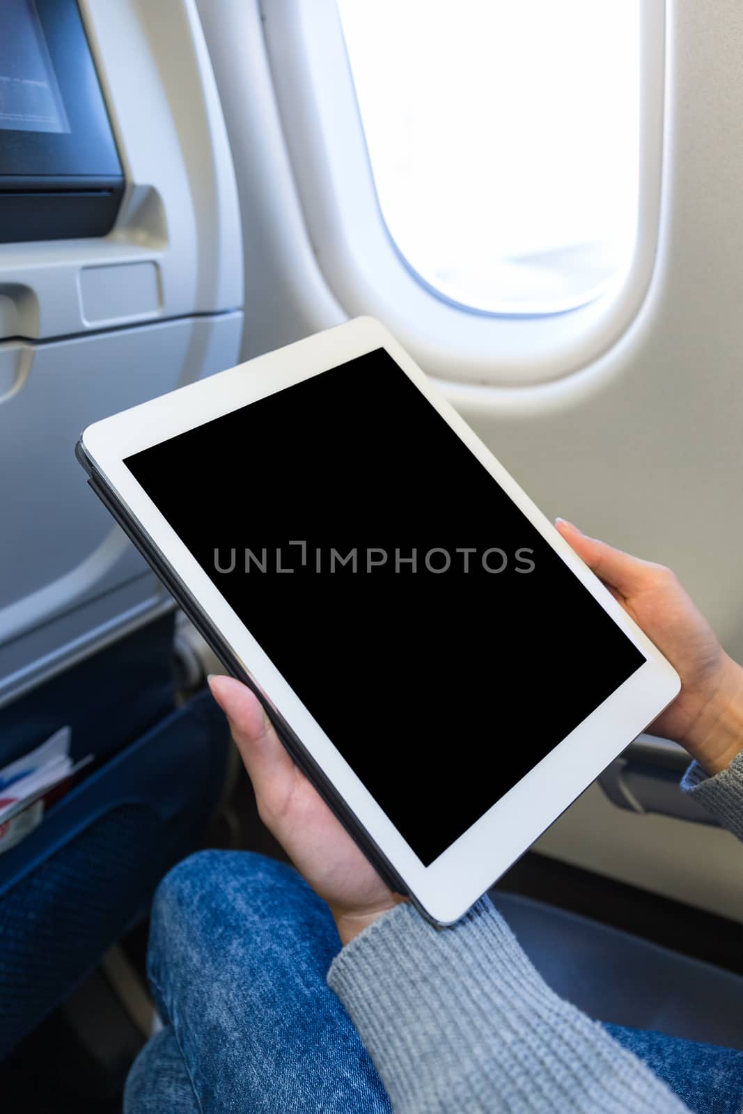 Woman using digital tablet on in plane by leungchopan