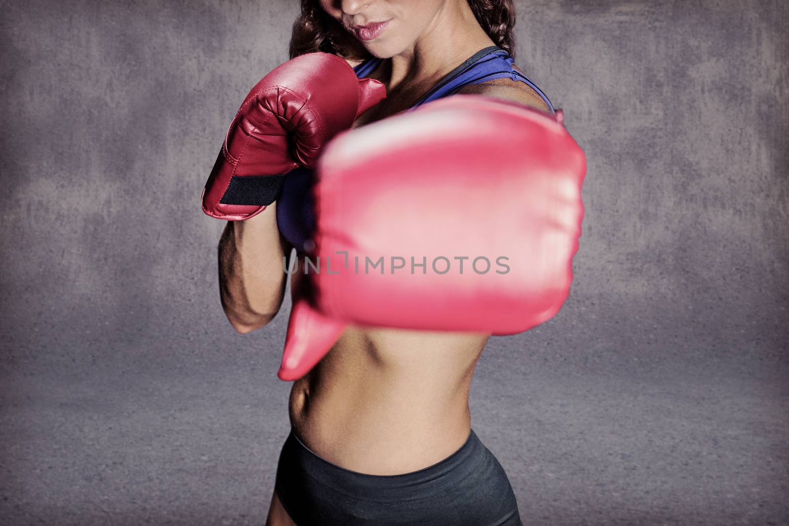 Portrait of athlete with fighting stance against grey wall