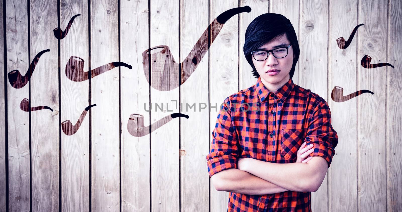 Serious hipster with crossed arms against wooden planks