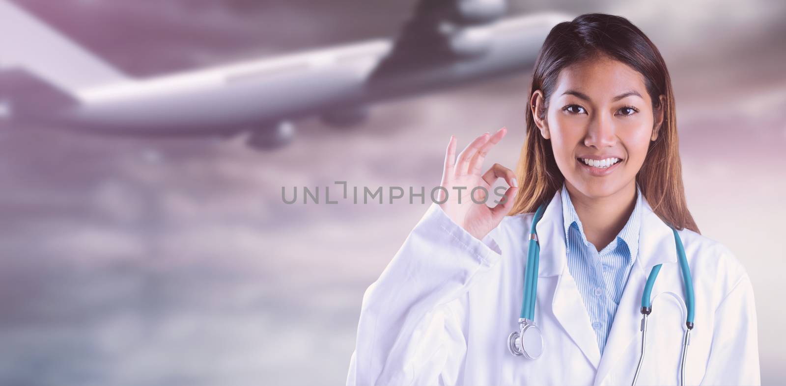 Asian doctor doing ok sign against heavenly water and sky