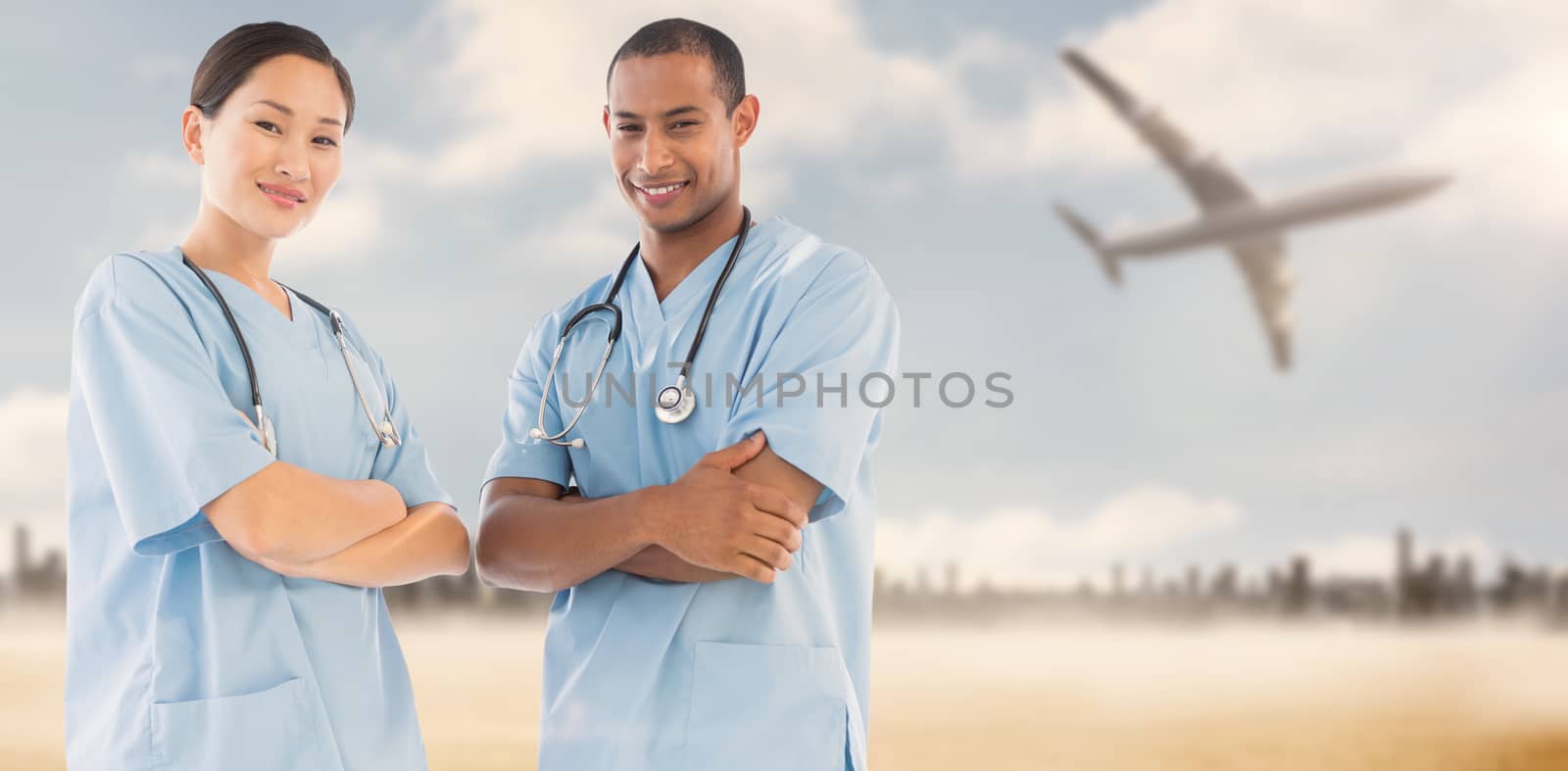 Confident surgeons with arms crossed in hospital against large city on the horizon