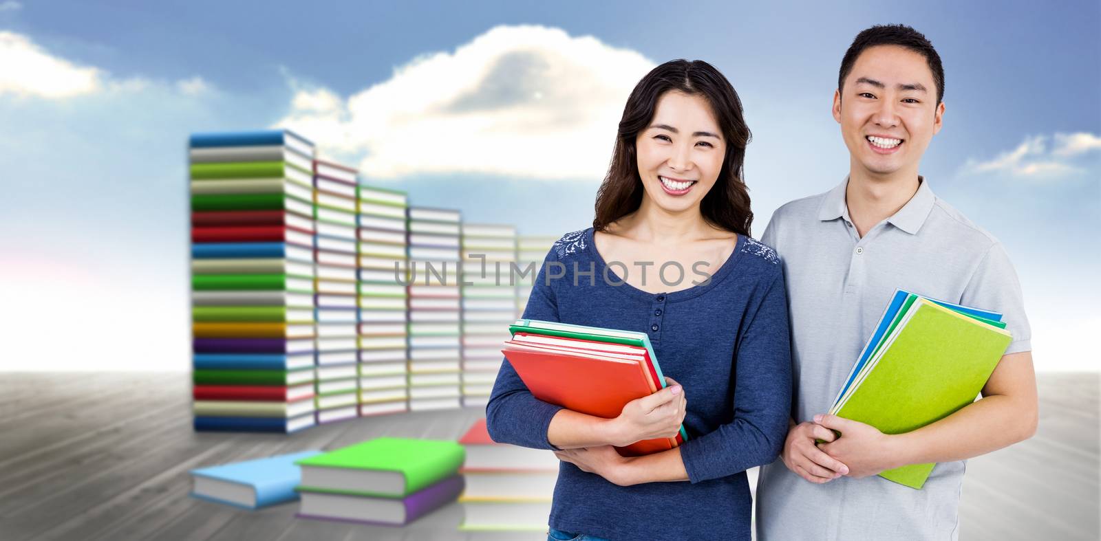 Happy couple holding books against steps made of books against sky