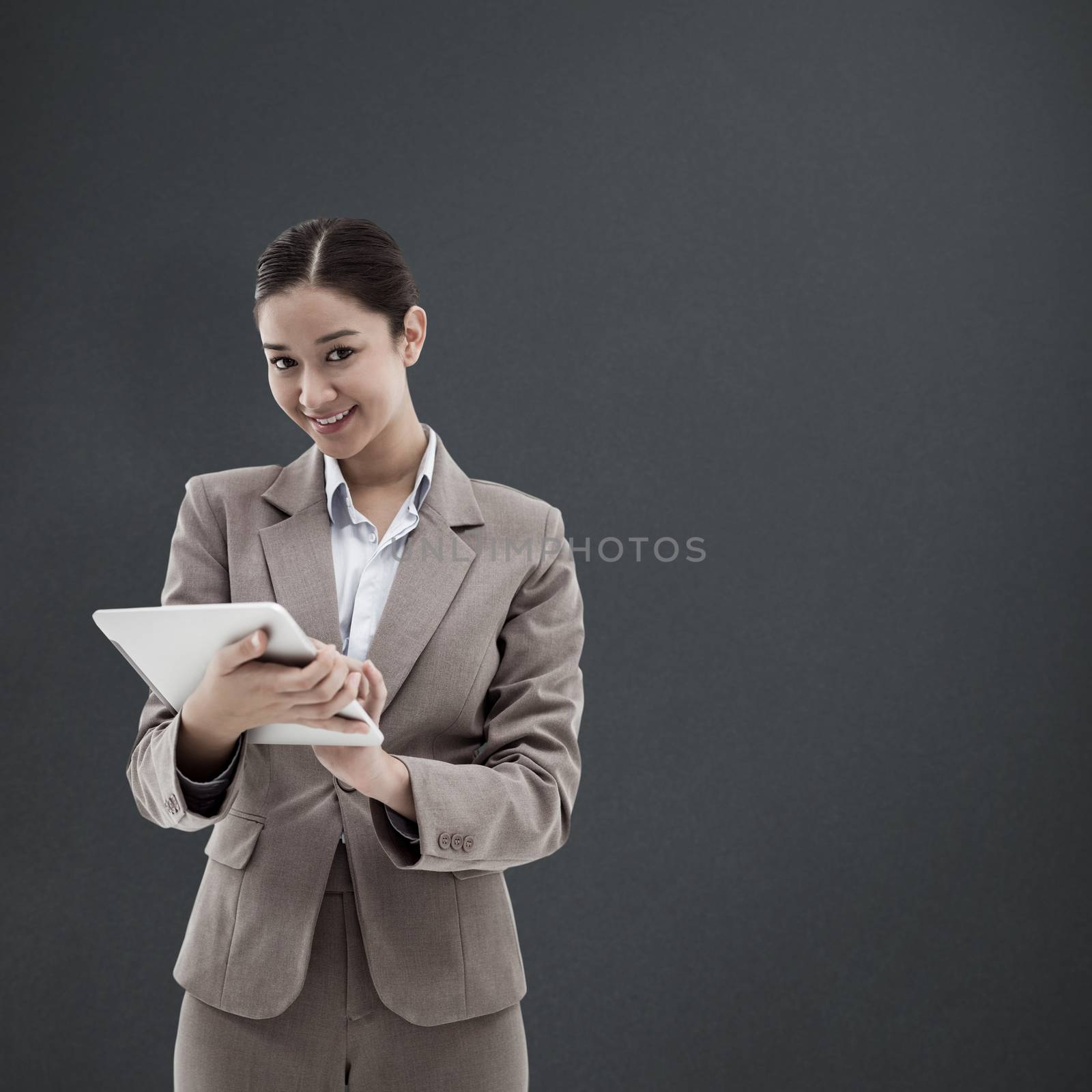 Composite image of portrait of a smiling businesswoman using a tablet computer by Wavebreakmedia