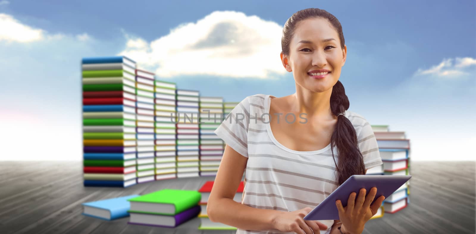 Businesswoman using tablet in the office against steps made of books against sky