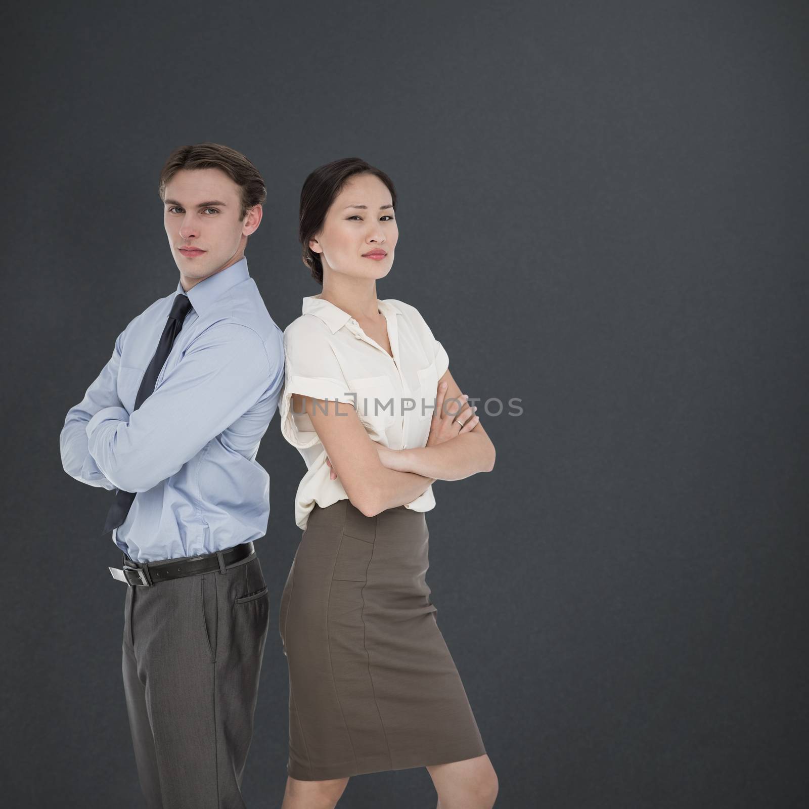 Business colleagues with arms crossed in office against grey background