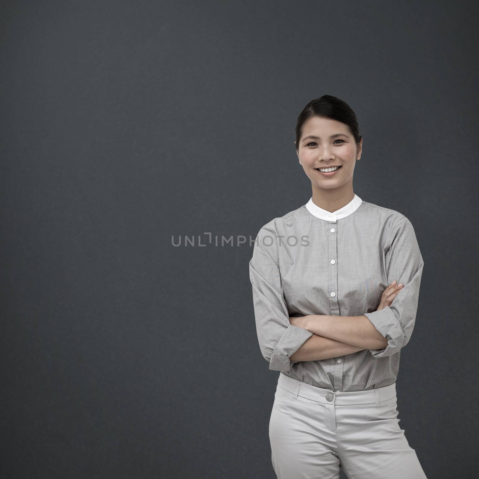 Composite image of selfassured businesswoman with folded arms  by Wavebreakmedia