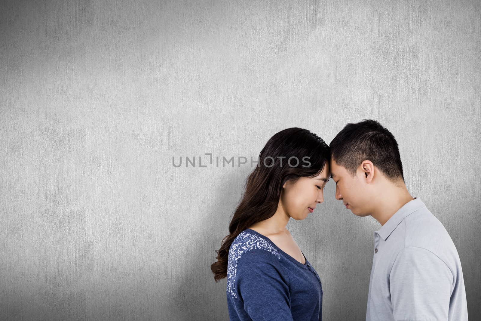 Loving couple head to head against white and grey background