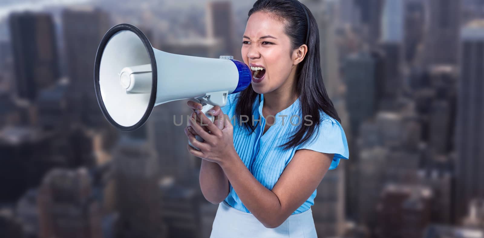 Businesswoman shouting into a megaphone against view of cityscape