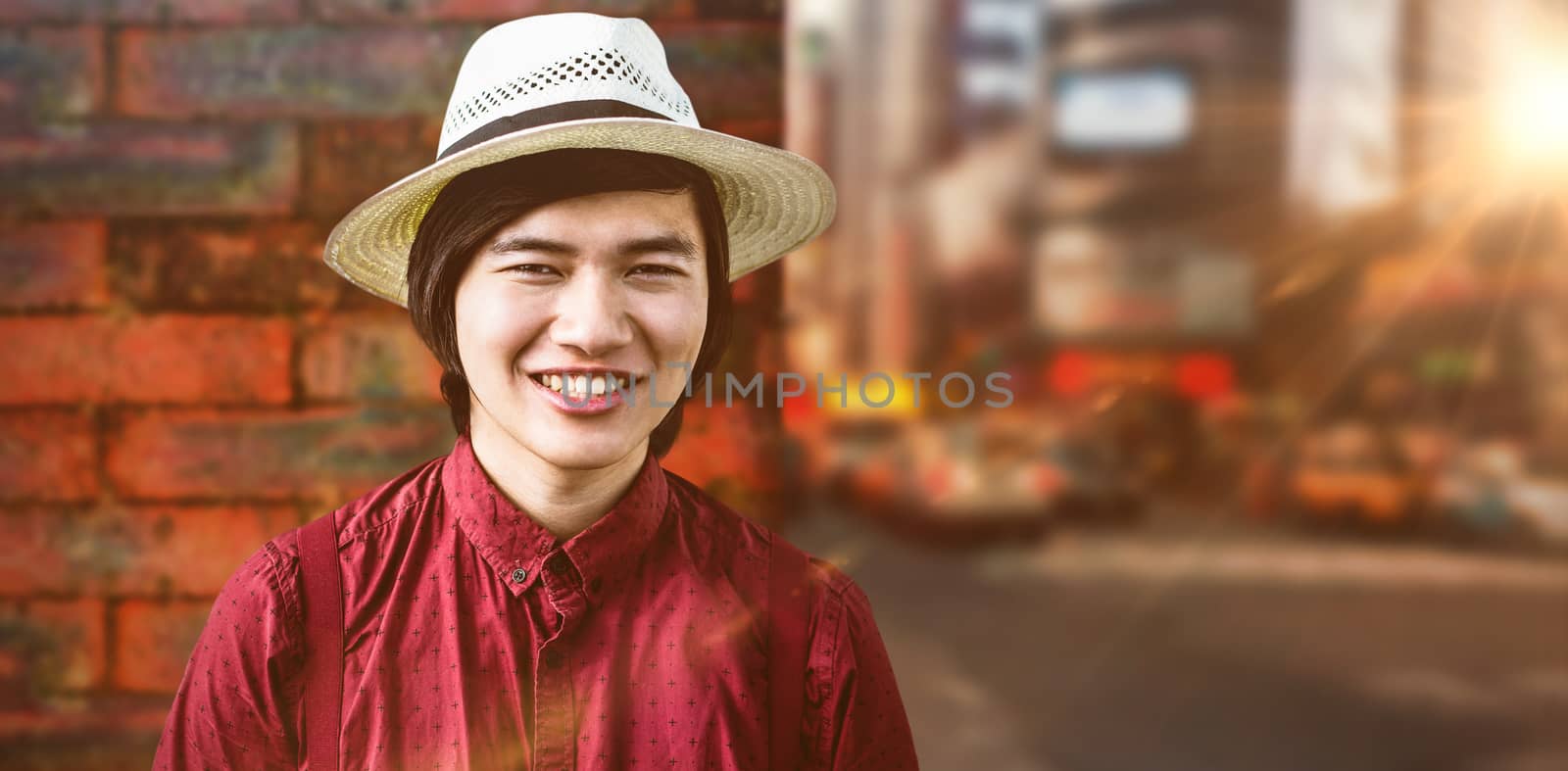 Smiling hipster with a straw hat against wall of a house
