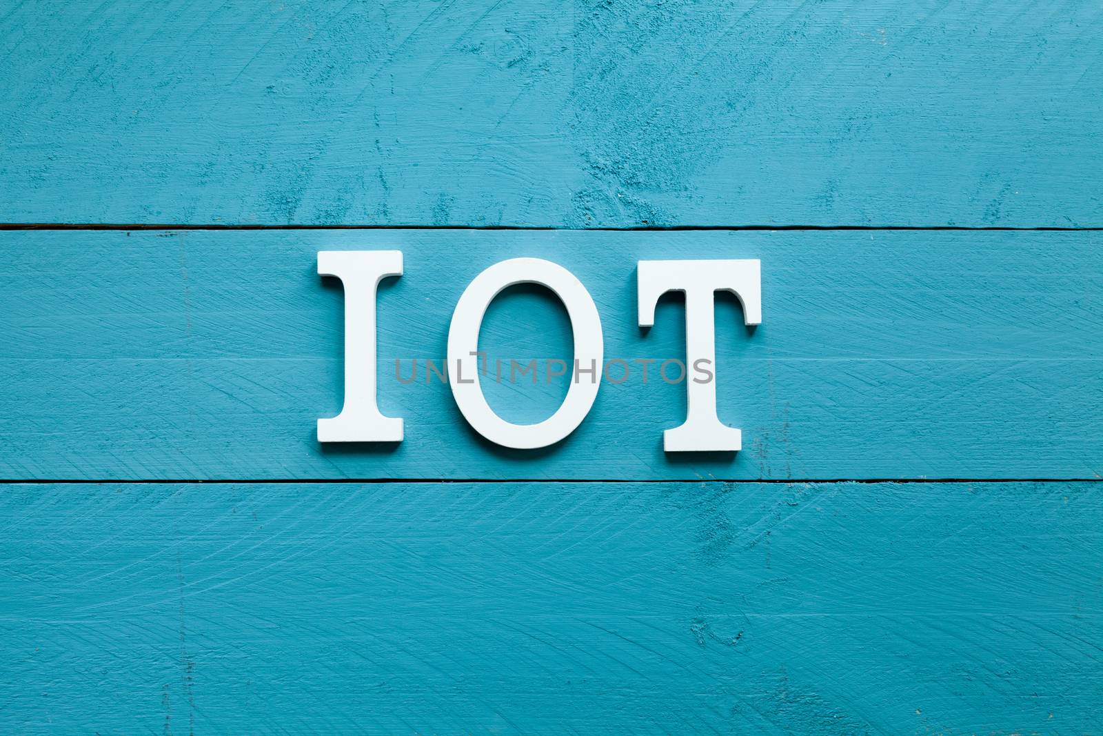 The acronym IOT Internet of things on blue background by andongob