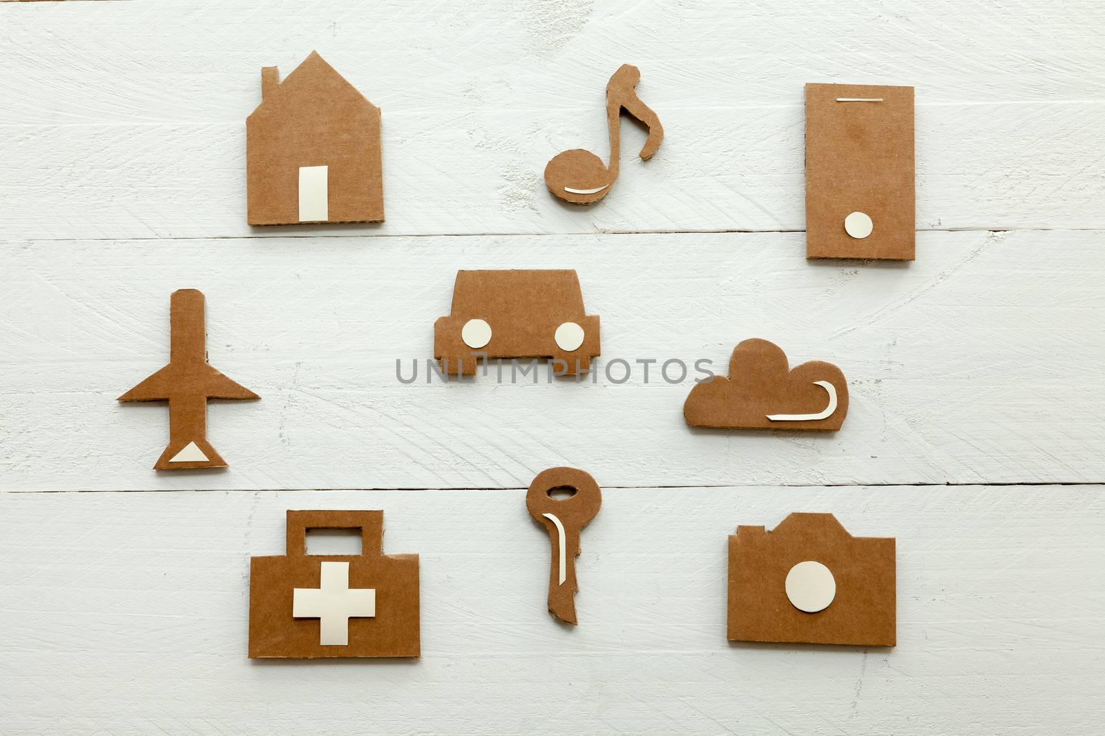 Set of web icons or graphical illustrations cut from cardboard and placed on white wooden background