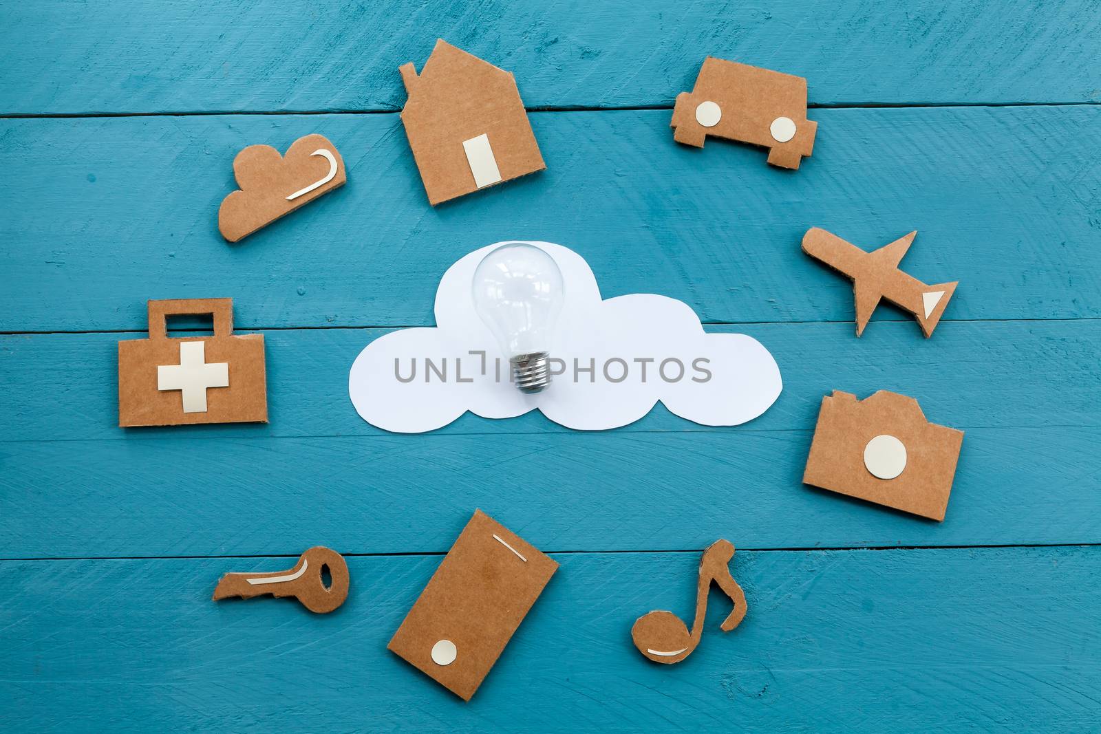 Set of web icons or graphical illustrations cut from cardboard and placed on blue wooden background