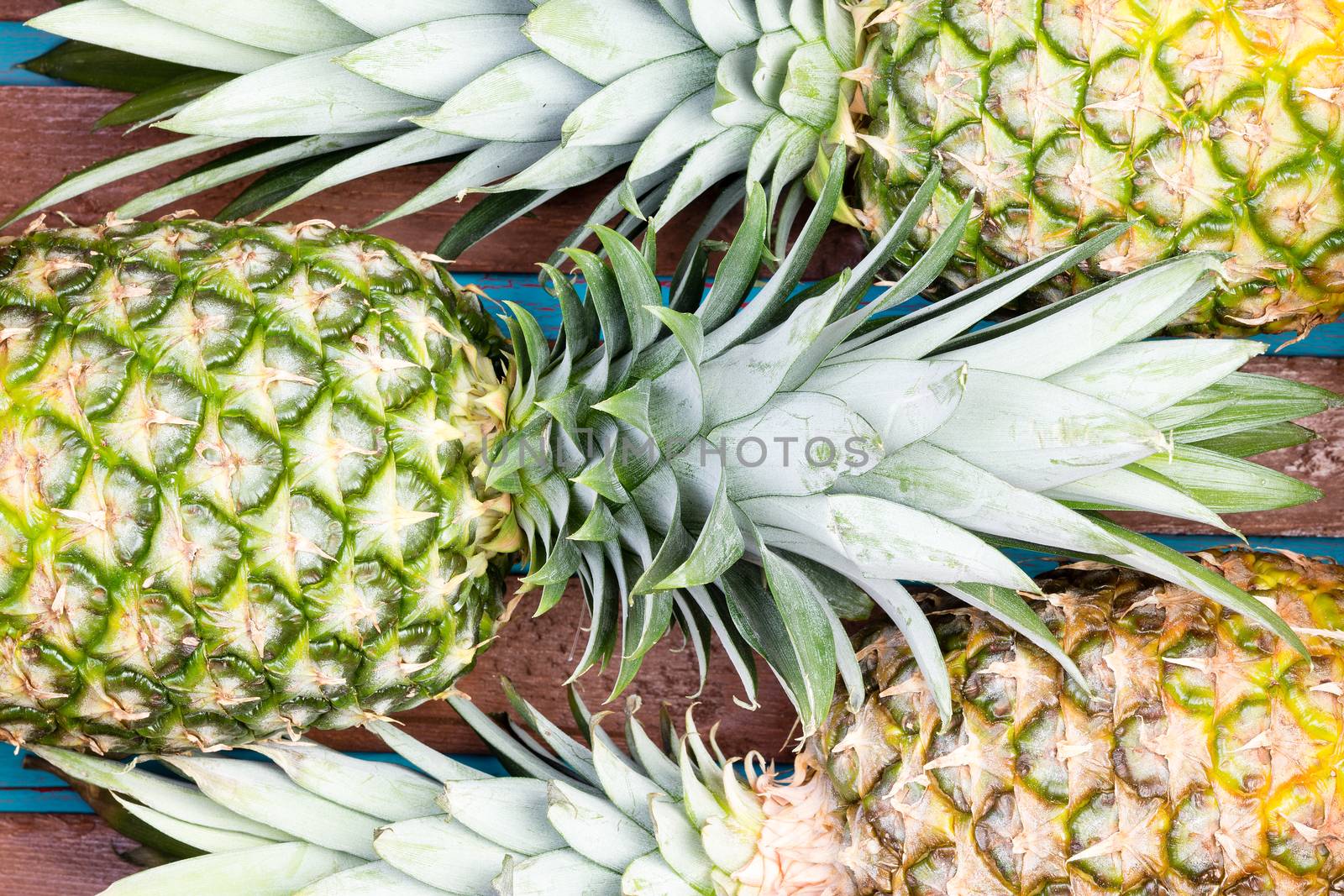 Three pineapple fruits close together by coskun
