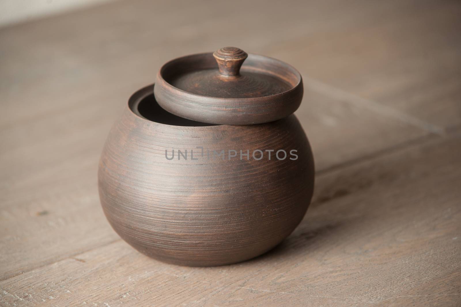 Traditional handcrafted brown pot with a cap