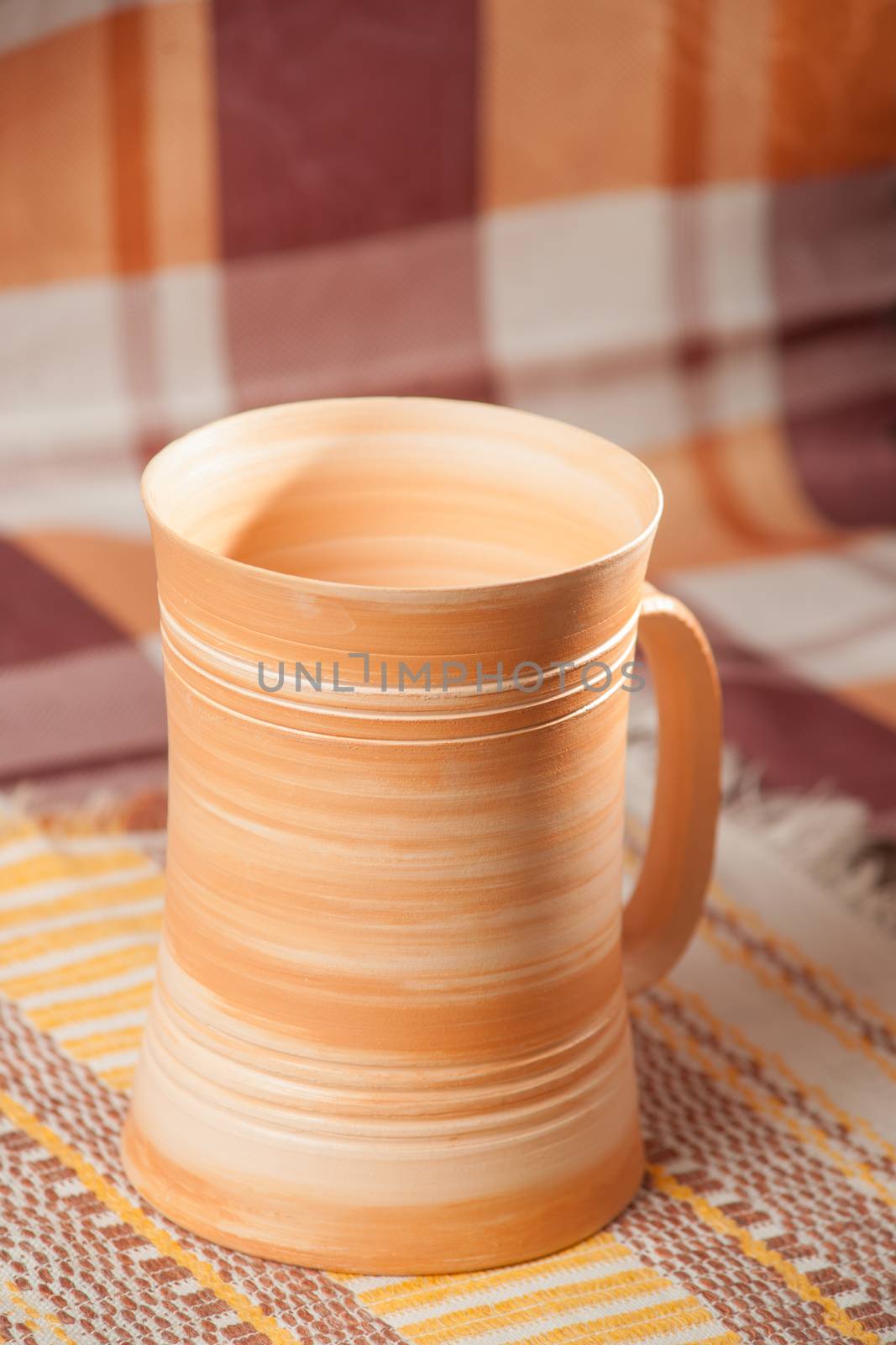 Traditional handcrafted mug on the multycolor background