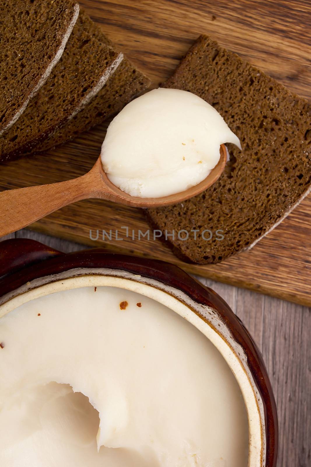 Melted fat and brown bread on chopping board by VIPDesignUSA