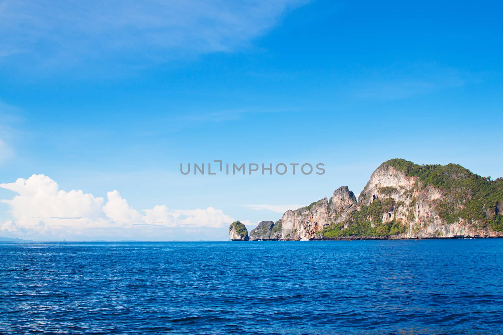  Deep blue Andaman sea view with cloudy sky and rock island on horizon