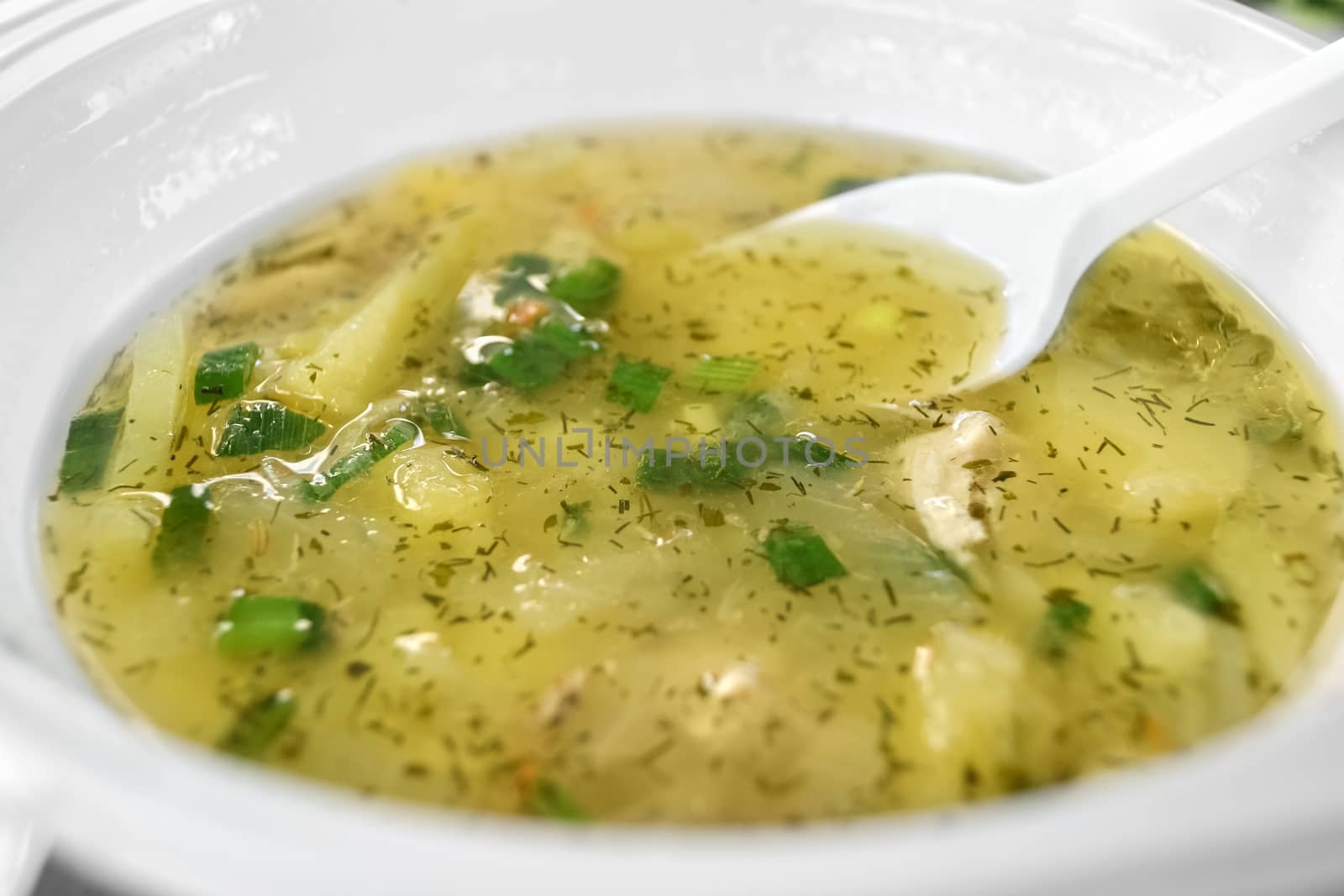 The soup is poured into a disposable plate and spoon.