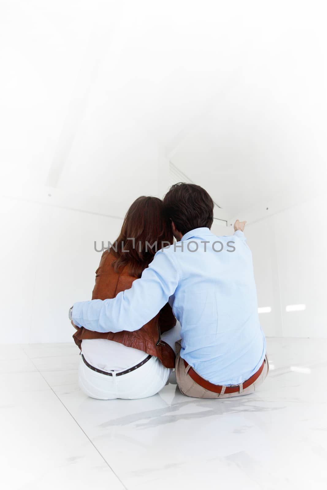 Couple sitting at their new empty apartment