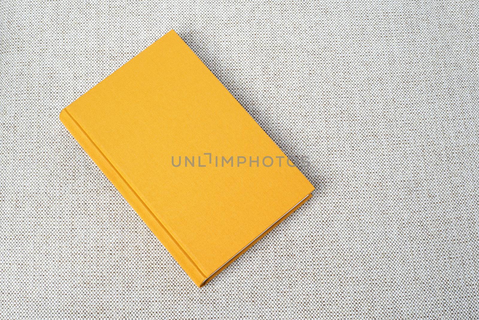 Yellow book on the grey fabric material background