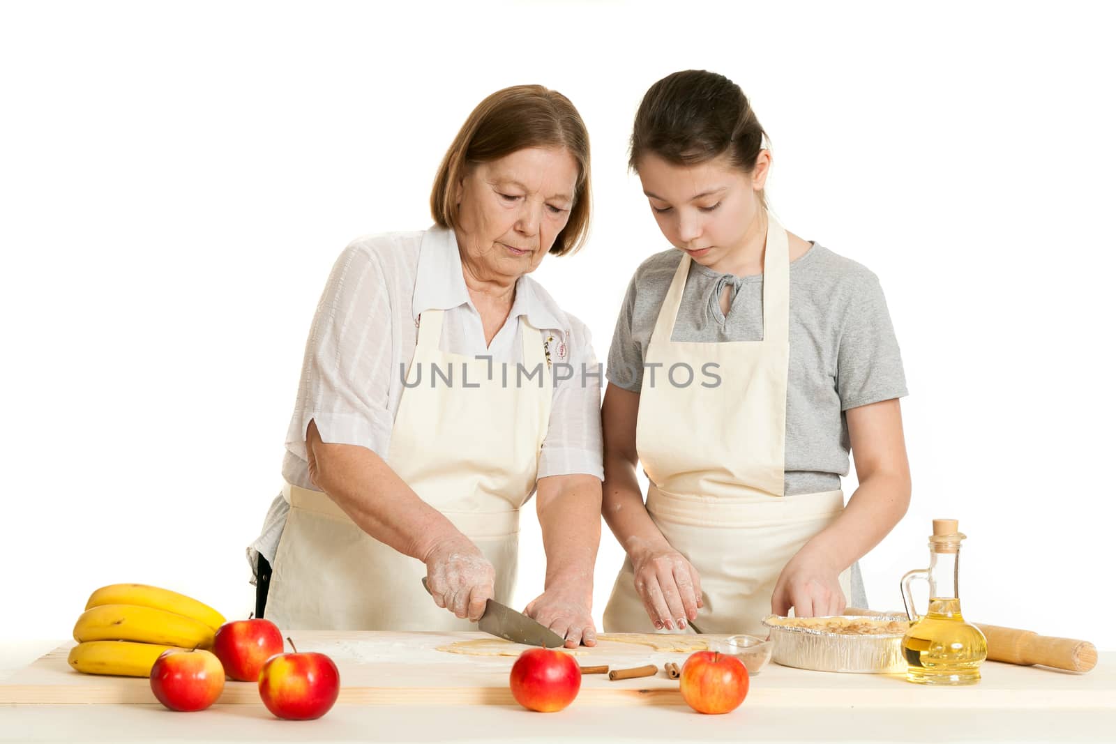the grandmother and the granddaughter stack dough strips for ornament in a form for pie