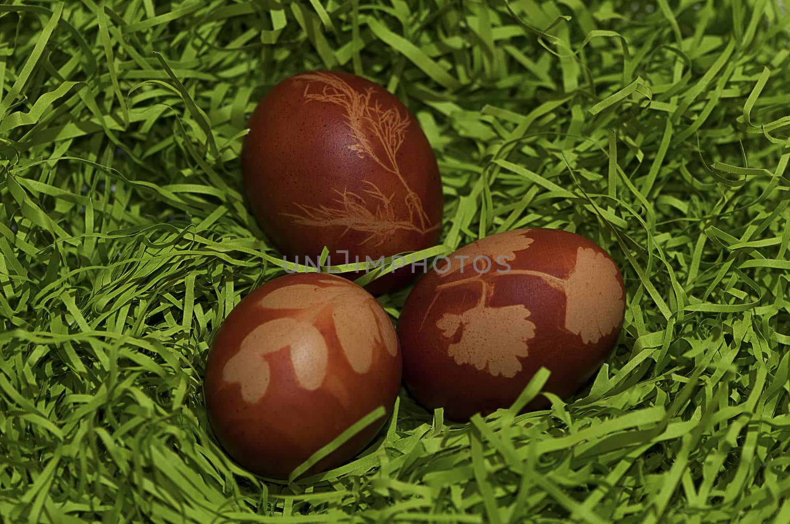 Red easter eggs with models on paper grass