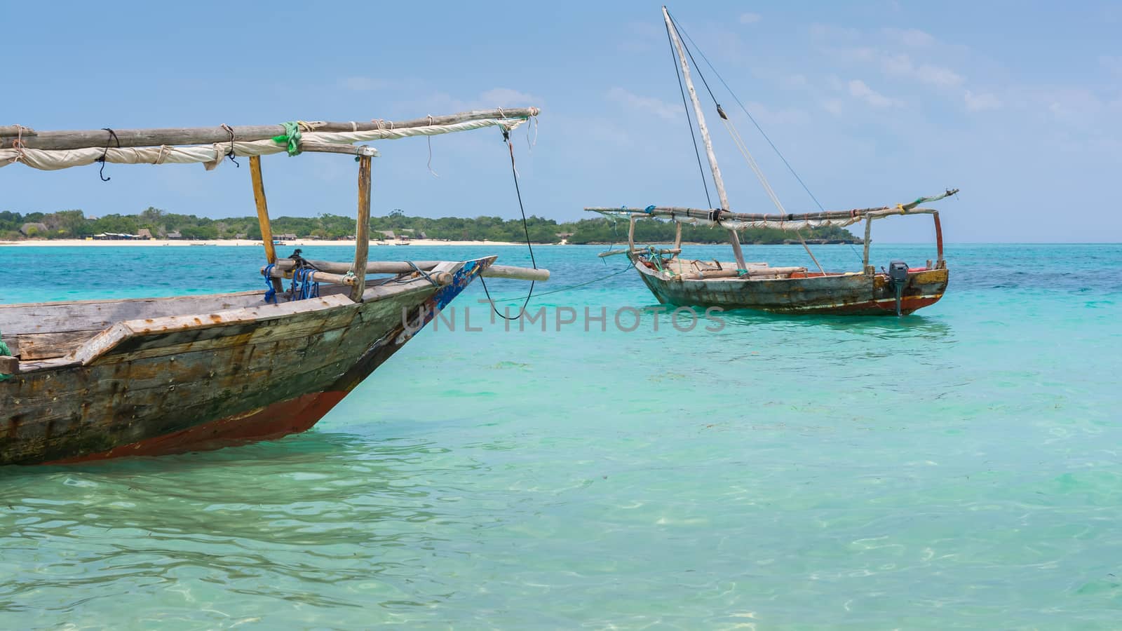 Anchored wooden dhow boats on the amazing turquoise water in the Indian ocean  Zanzibar, Tanzania.