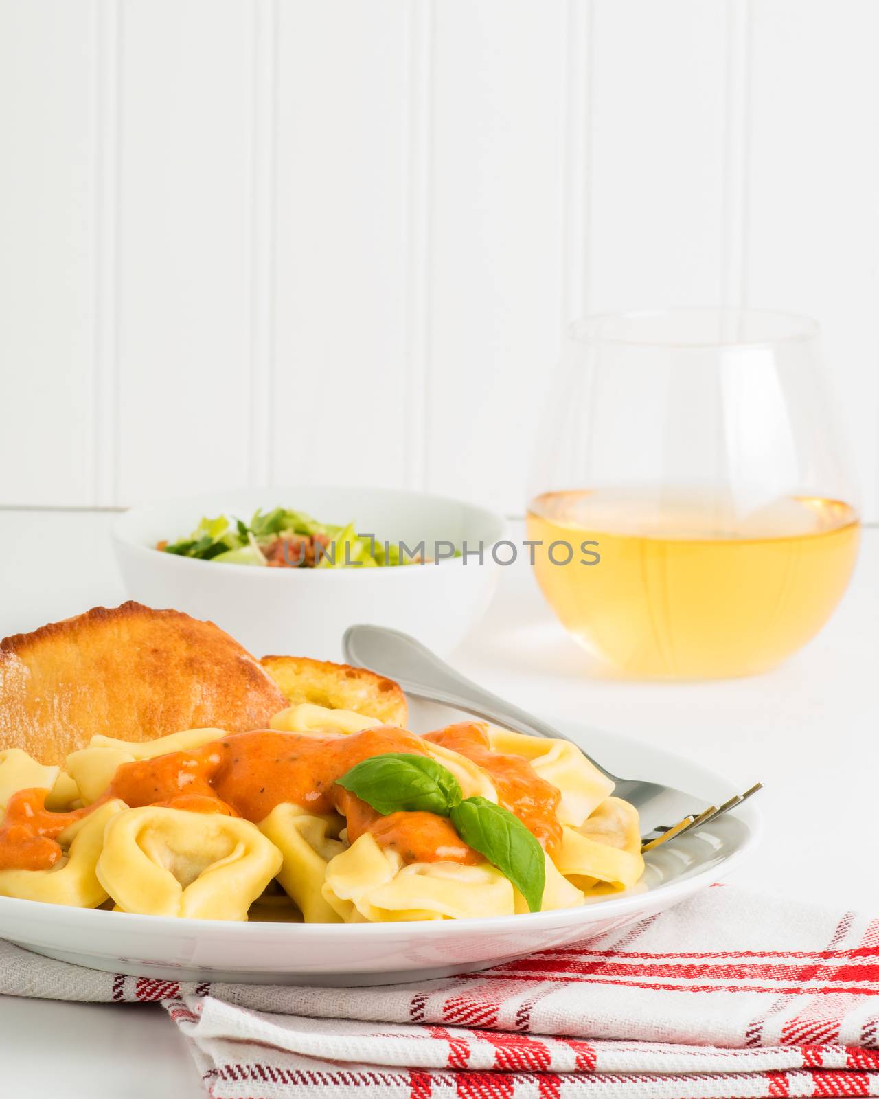 Meal of tortelloni and caesar salad.  Useful on menus and for other food services marketing.