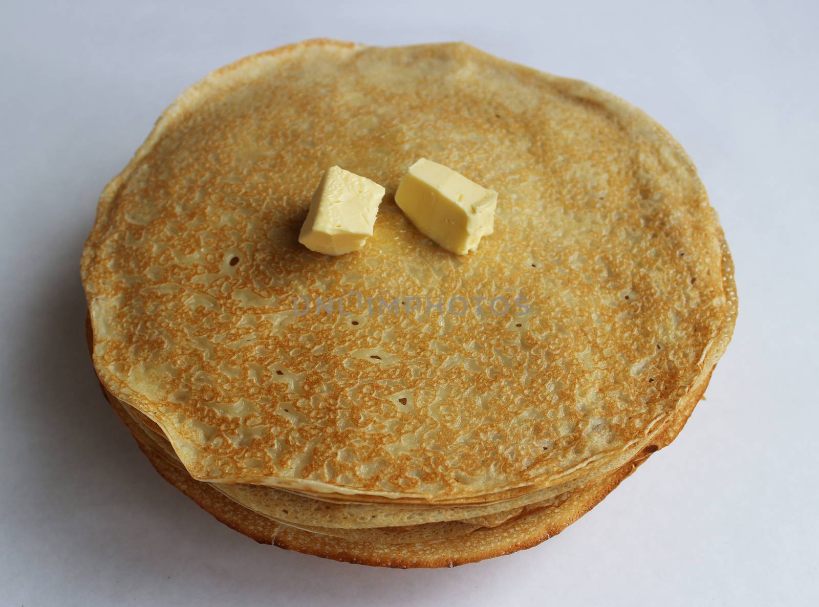 Pancakes with butter on a plate, as a symbol of ancient Slavic celebration of Carnival. Meet spring, winter farewell.