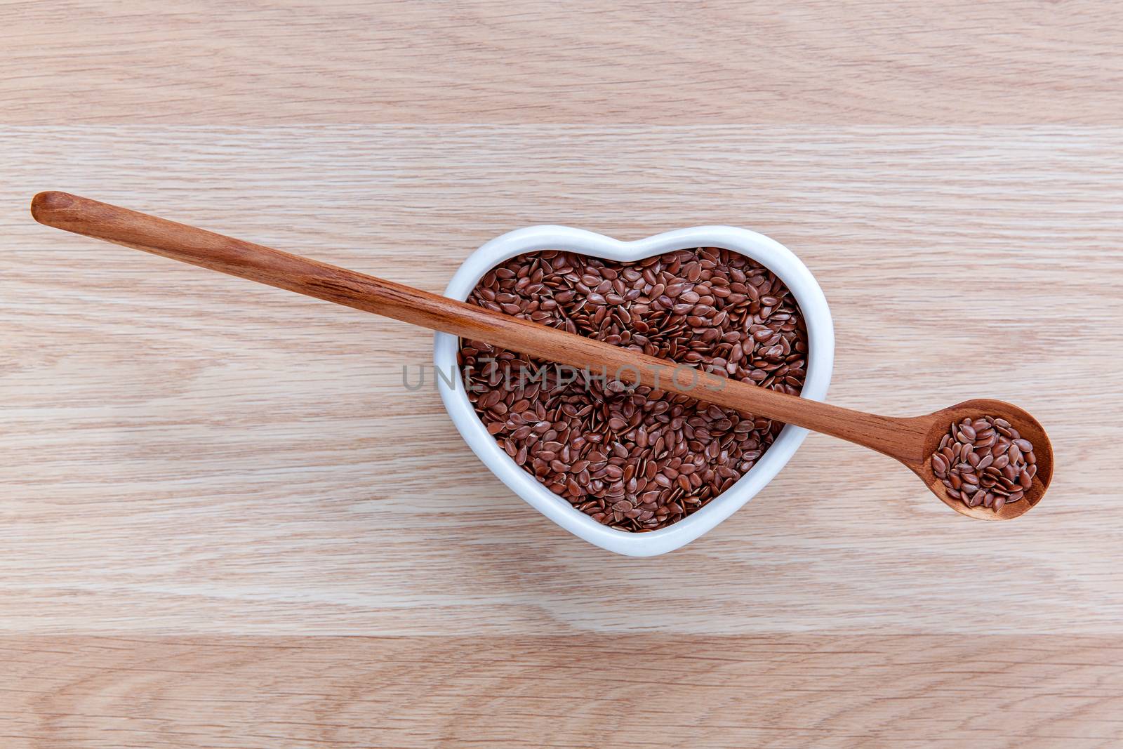 Alternative health care and dieting flax seeds in wooden spoon set up on rustic wooden background.