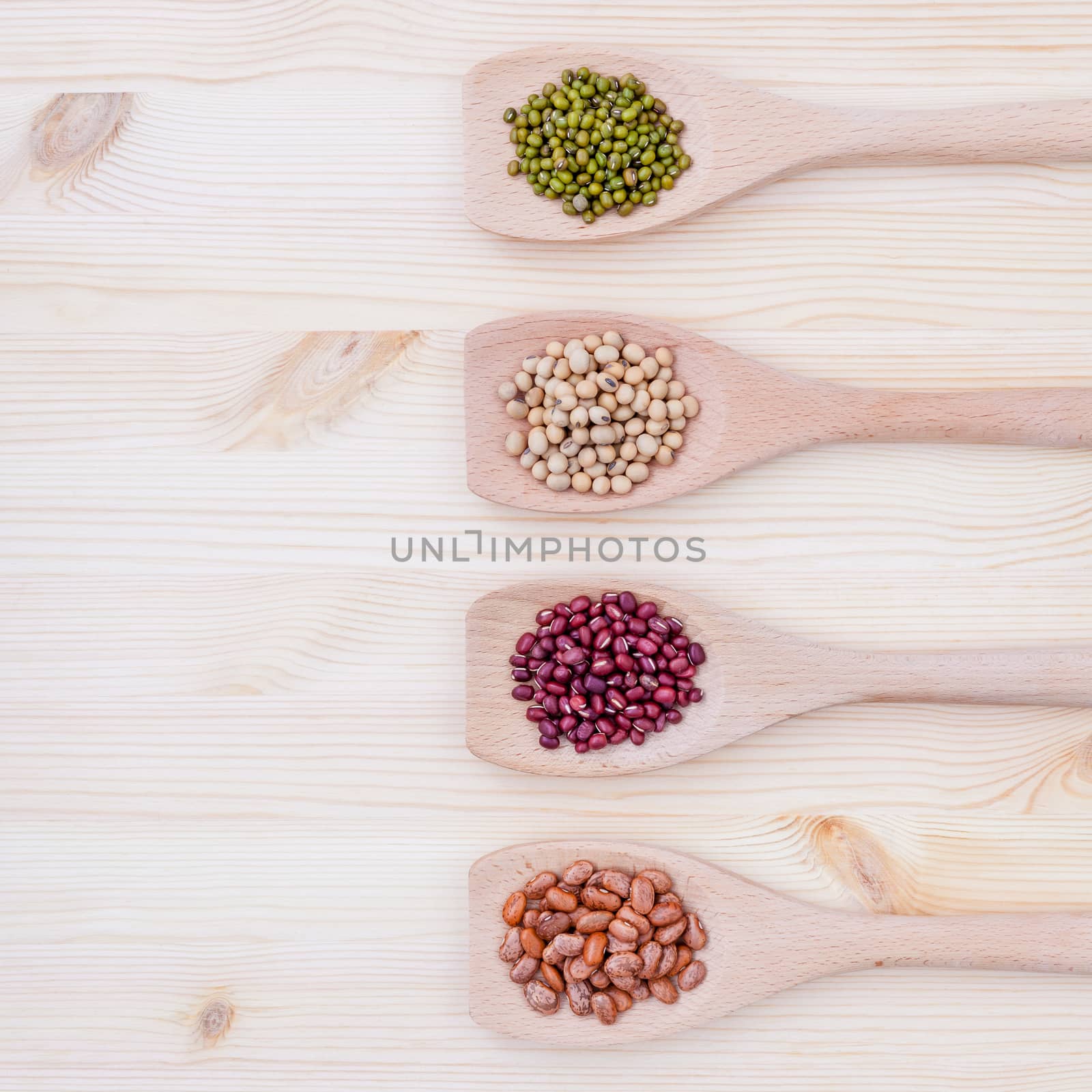 Assortment of beans and lentils in wooden spoon on wooden background.  soybean, mung bean , red bean and brown pinto beans .