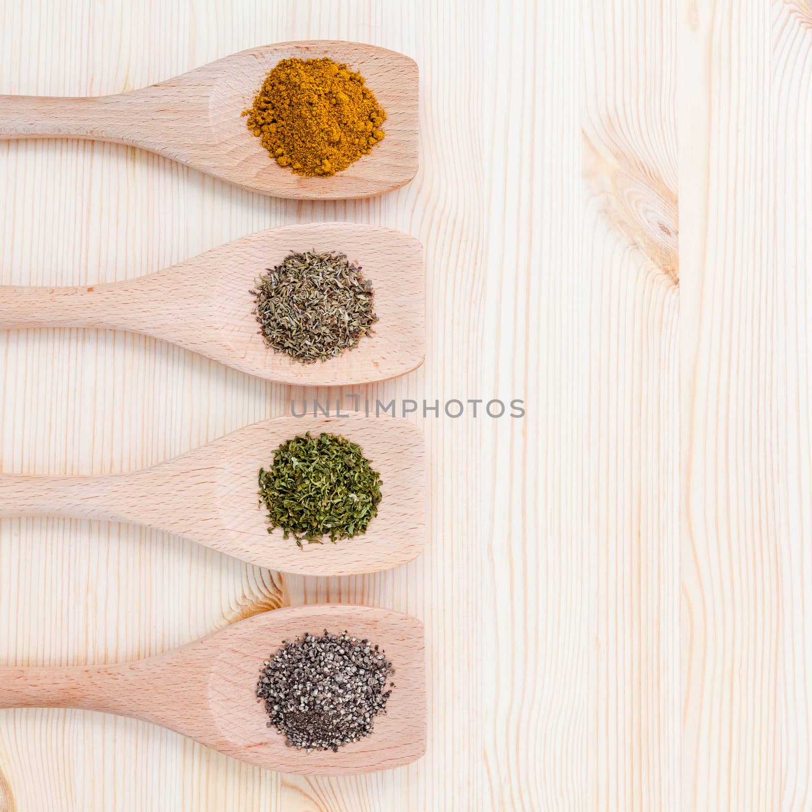 Food Cooking ingredients. Dried Spices curry powder ,black pepper ,powder,oregano and thyme in wooden spoons on rustic wooden background.