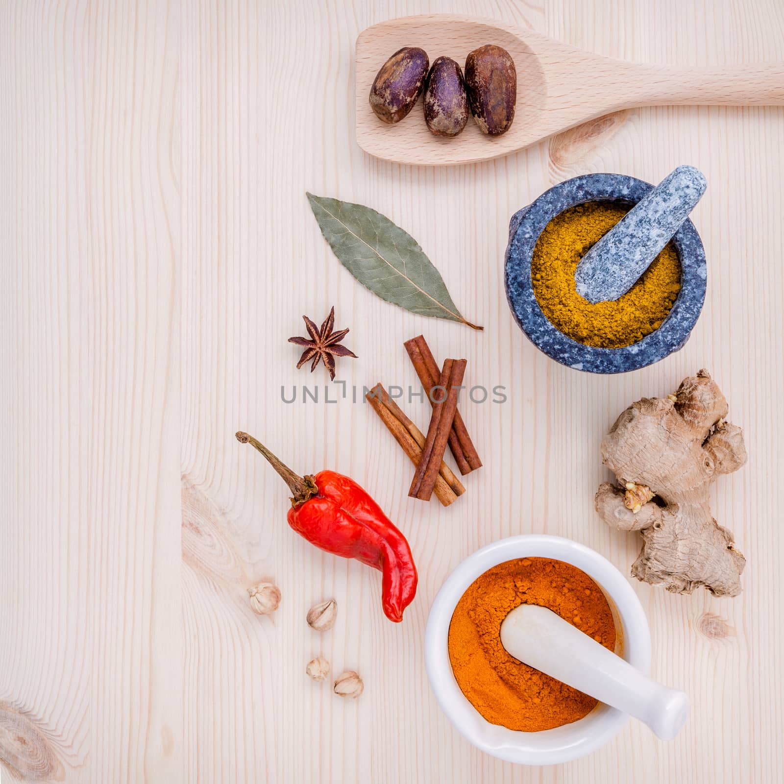 Dried herbs and spices nutmeg,star anise ,cinnamon stick ,ginger ,bay leaves and chili on wooden table. Top view with copy space.
