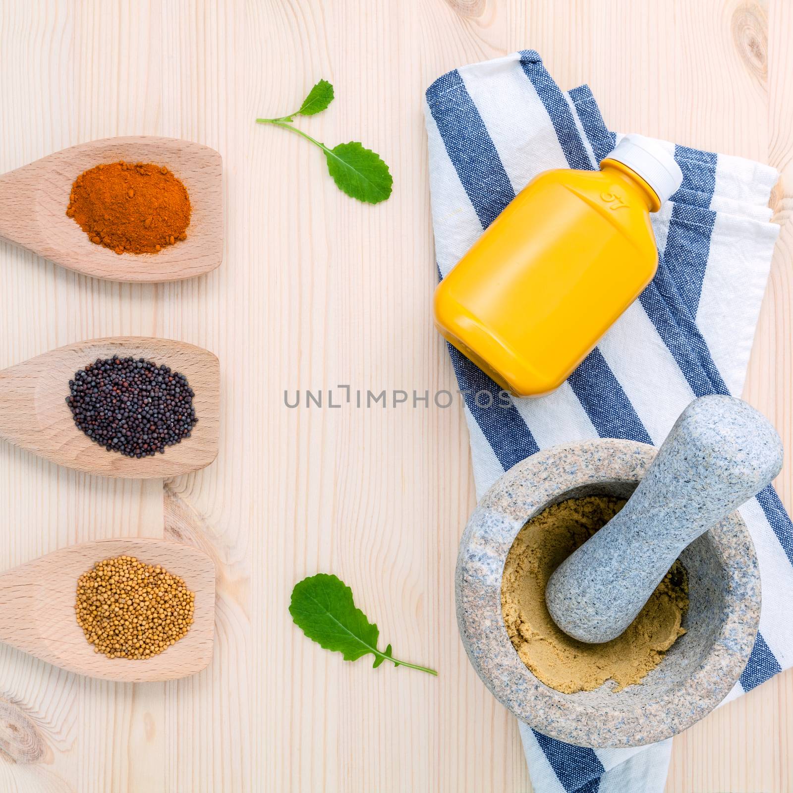 Dried mustard seeds black and yellow  with turmeric powder in wooden spoons and mustard poder in the mortar on rustic wood background .Top view with copy space.